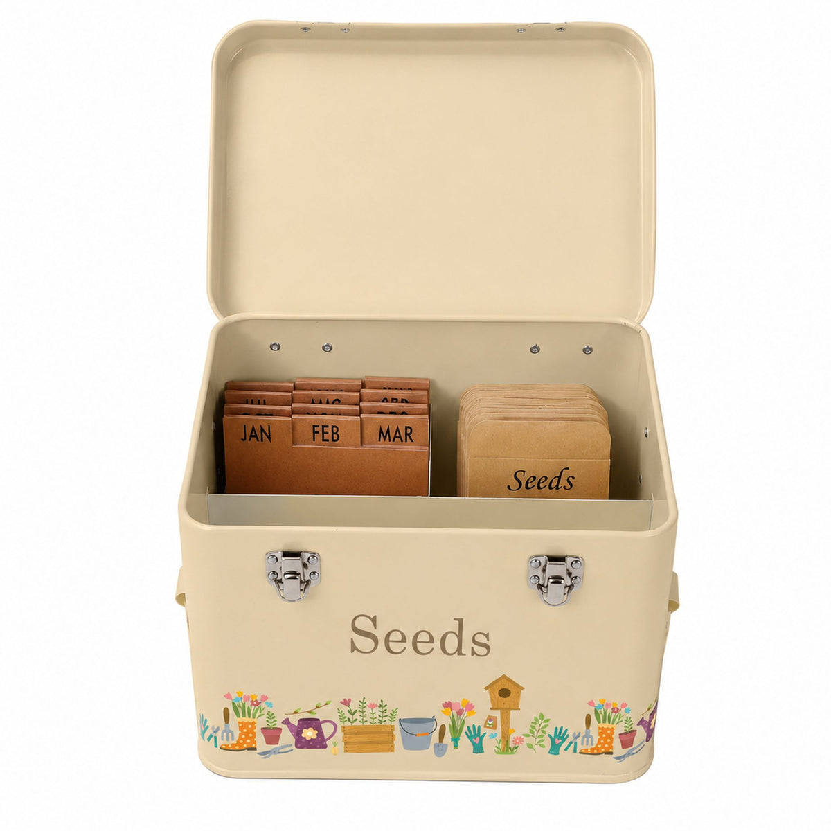 An open cream-colored metal seed storage box with a hinged lid, featuring a colorful garden illustration along the bottom edge and the word 'Seeds' printed on the front. Inside, wooden monthly seed folders and a stack of seed packets are stored.