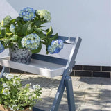 Grey and white shelving with plants in garden