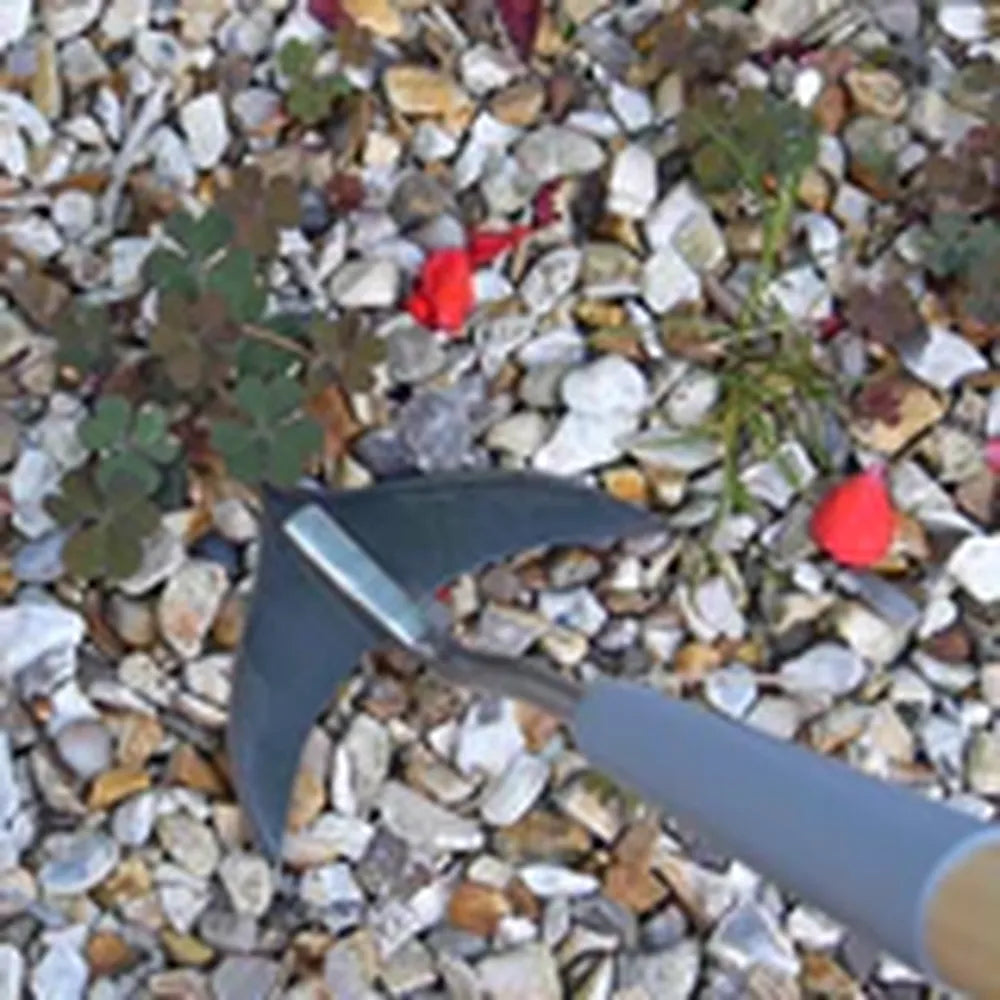 short handled weed slice tool by gravel and weeds
