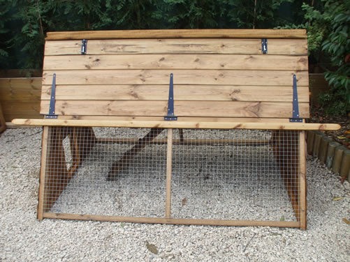 small wooden chicken house with run in garden placed on gravel