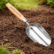Hand soil scoop with wooden handle and stainless steel head digging compost and garden soil for planting and potting