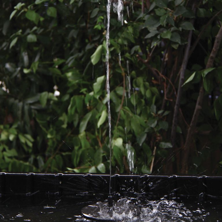 Solar fountain in pond with water coming out in a garden