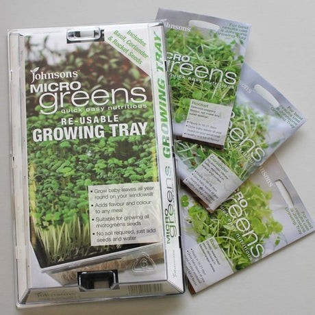 A reusable growing tray labeled 'Johnson's Micro Greens' accompanied by three packets of seed.
