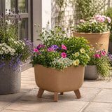 Decorative plant pot light brown with legs with flowers on a patio