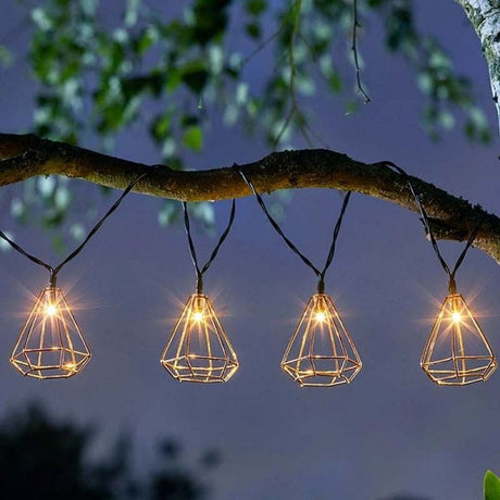 String lights with geometric-shaped cages hanging on a tree, featuring multiple small lights inside each cage.