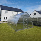 Greenhouse on grass with houses in the background