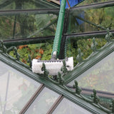 A close-up of a swop top brush  attached to a metal pole cleaning the glass of a greenhouse.