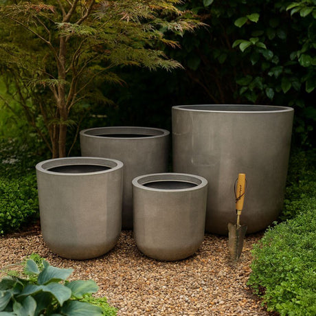 different sizes of large grey flower pots in the garden