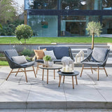 String effect patio sofa and 2 chairs and table sat infront of building on slabs
