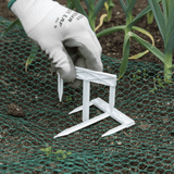 tri pegs being placed into secure garden netting