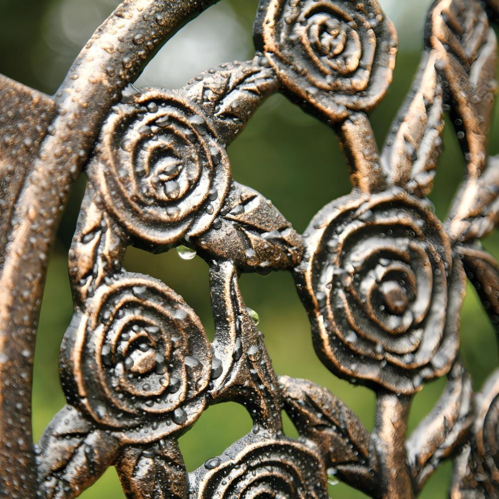 Coalbrookdale inspired rustic cast iron bench displayed on grass with colourful bushes and trees in the background