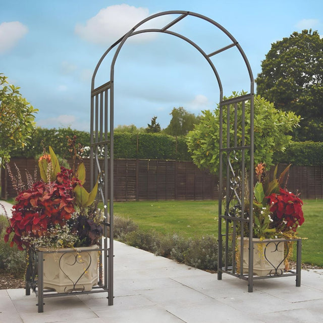 Huntingdon Ornamental Arch with Planter Holders in a colourful garden with a blue sky 