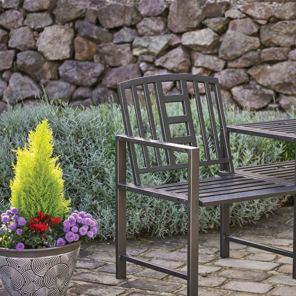 Two black metal chairs with a table on top