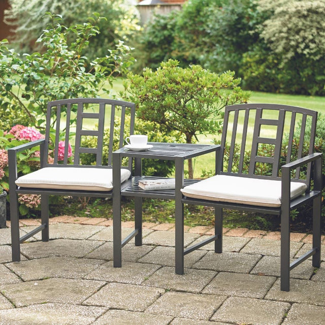 Two cushioned chairs on a patio, inviting relaxation and comfort in an outdoor setting.