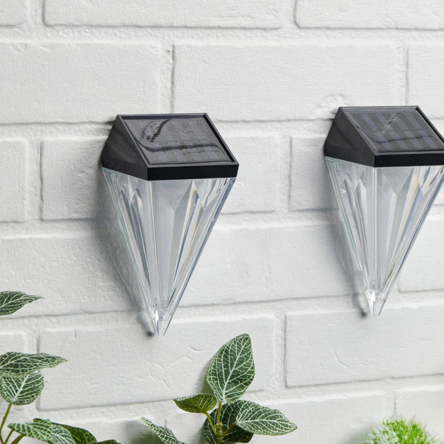 Diamond solar wall lights displayed on a white brick wall.