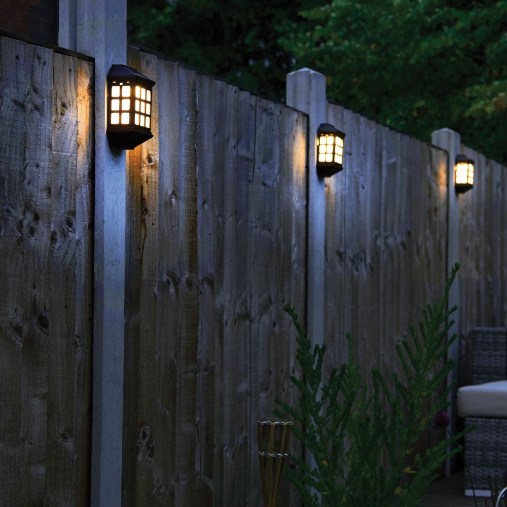 wall lights displayed on fence posts illuminating the garden and its close surroundings.