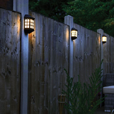 wall lights displayed on fence posts illuminating the garden and its close surroundings.