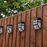 Solar fence lights off during daylight, displaying on a painted wooden fence.