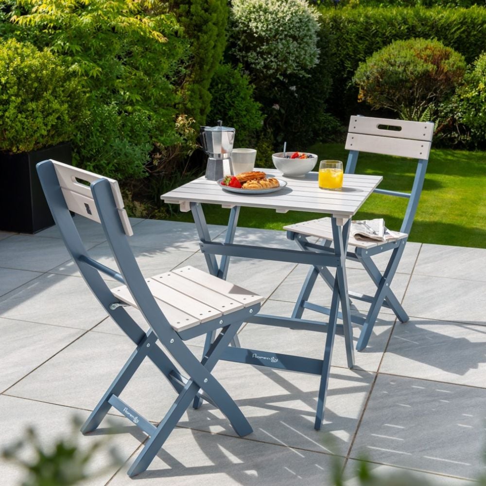 outdoor bistro set in the garden with breakfast on the table