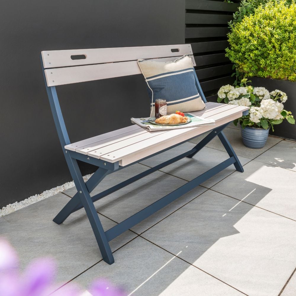 Outdoor folding bench in a modern garden in front of a dark grey wall