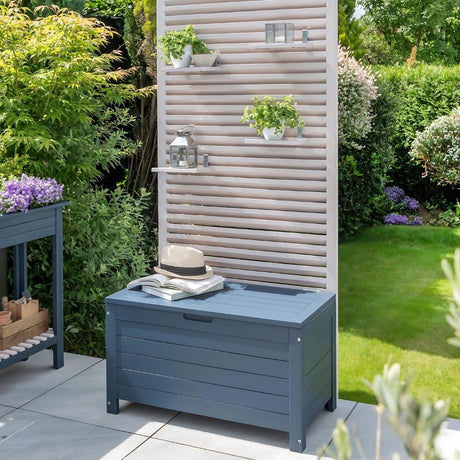 A garden bench surrounded by lush plants and featuring a convenient shelf for displaying decorative items.