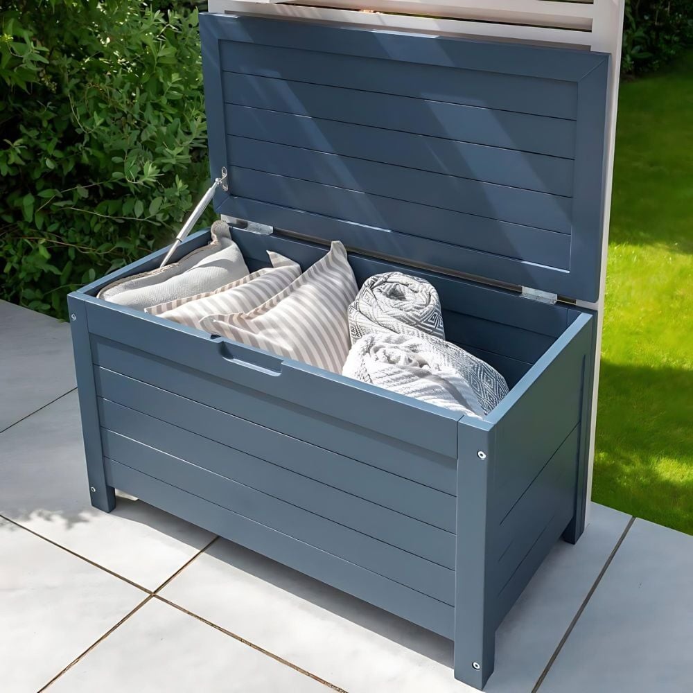 Blue outdoor storage box filled with towels and blankets.