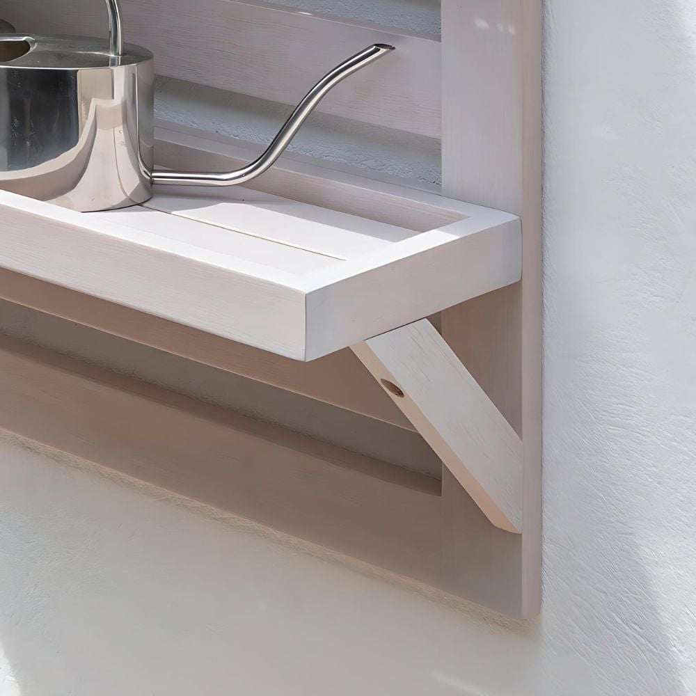 A shelf with a green plant in a white pot