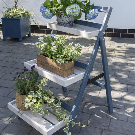 A wooden ladder adorned with blue flowers, adding a touch of color and charm to its rustic appearance.