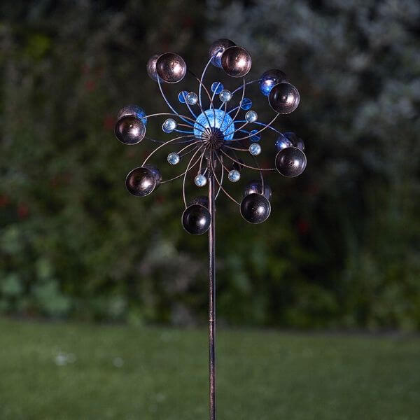 A garden wind spinner with rotating arms and a color-changing globe, featuring a brushed bronze effect finish.