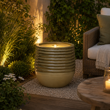 Decorative outdoor water feature with a chair and table in a garden setting