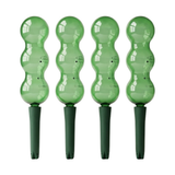 Four green plastic plant markers with wavy design on a white background