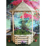 wooden wishing well planter in front of a garden background